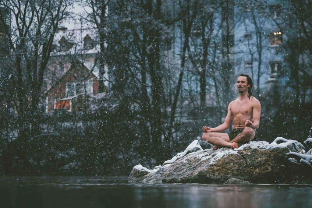 Luke Goodlife meditating in Snow om a rock